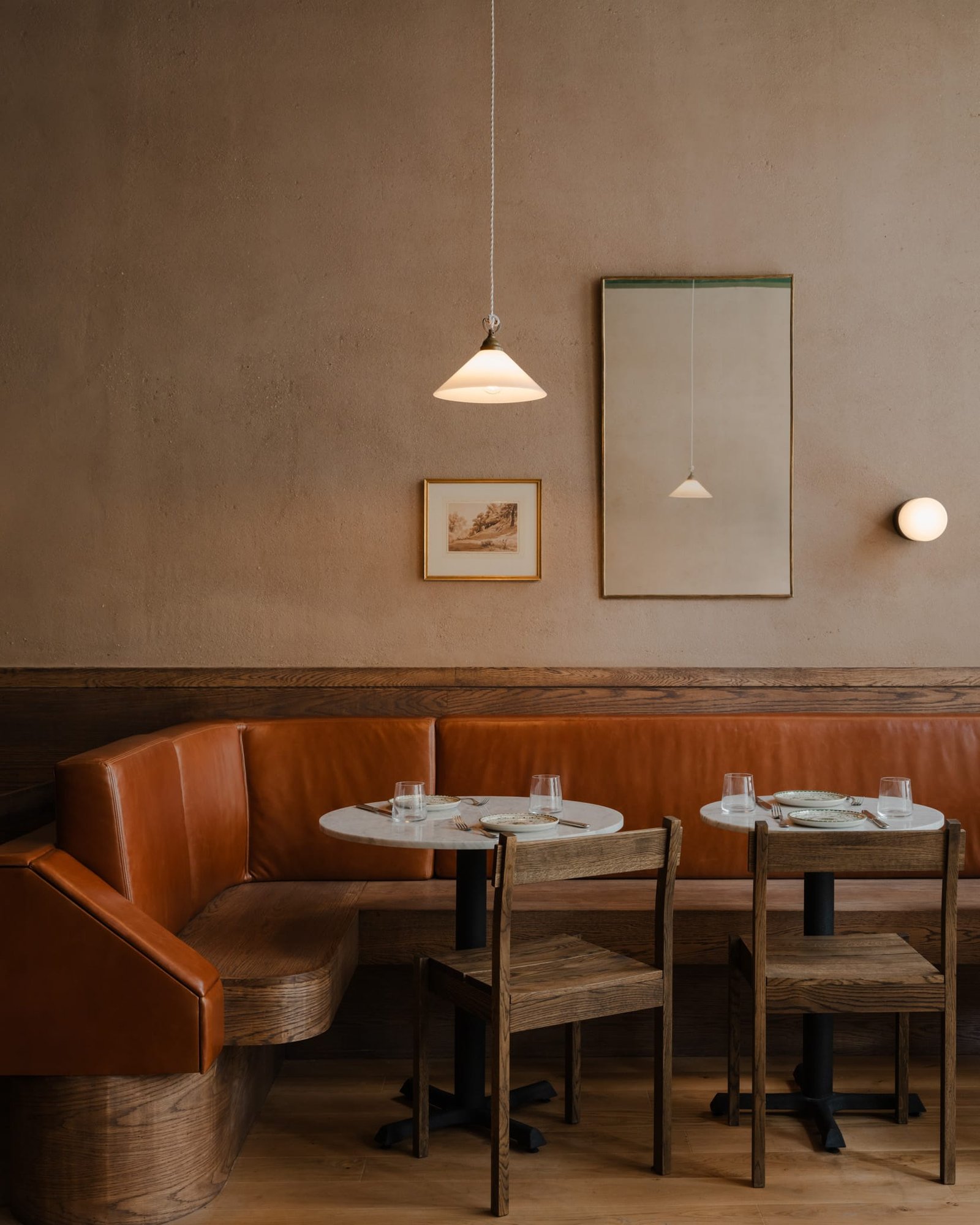 Smooth brown clay plaster above a terracotta leather banquette at Massara restaurant, New York
