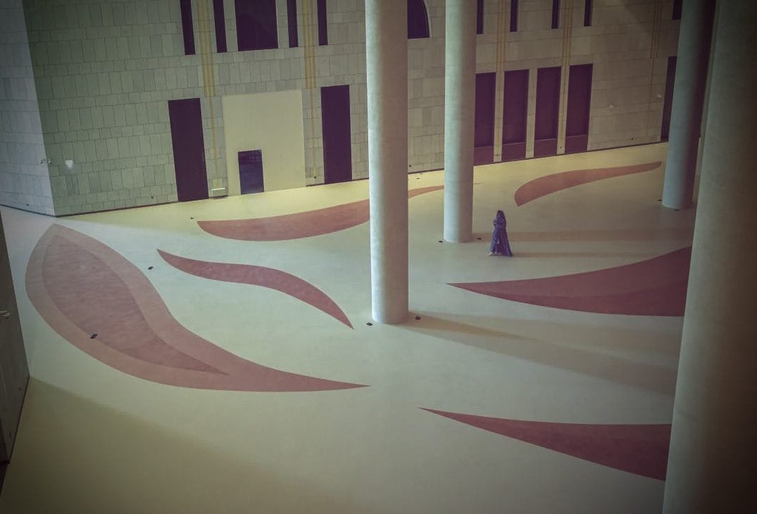 Dusty-rose leaf inlays sweeping across a cream Microdur Plus microcement floor, King Fahad Cultural Centre